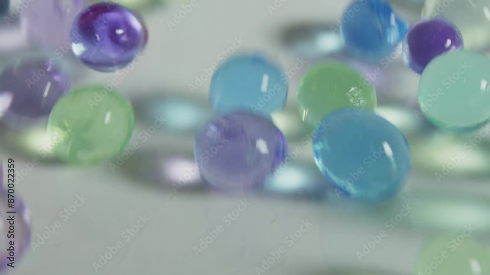 A bunch of colorful glass beads are scattered on a white surface. The beads are of various sizes and colors, creating a vibrant and lively scene. Concept of creativity and playfulness A bunch of colorful glass beads are scattered on a white surface. The beads are of various sizes and colors, creating a vibrant and lively scene. Concept of creativity and playfulness