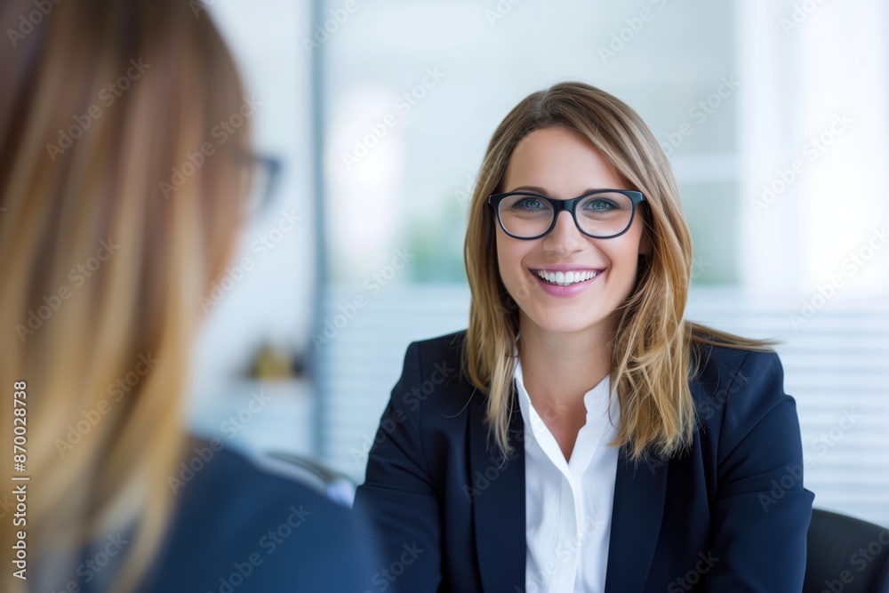 Smiling Female Manager Interviewing an Applicant In Office Smiling Female Manager Interviewing an Applicant In Office