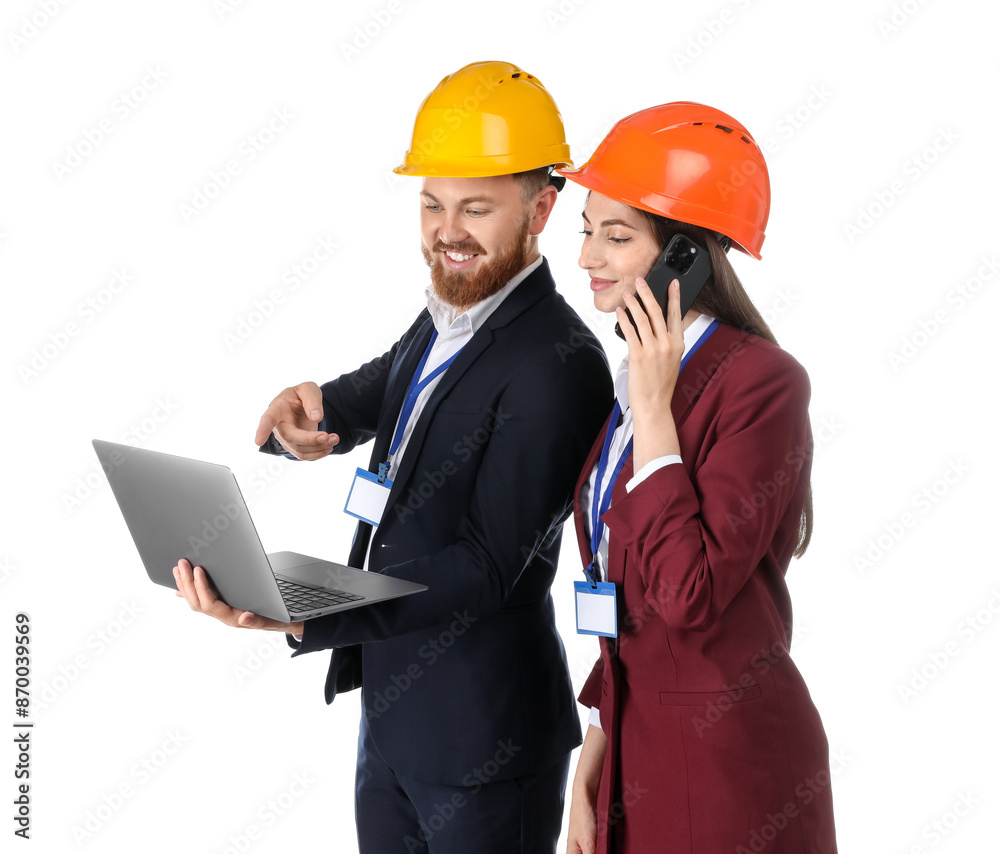 Engineer holding laptop while his colleague talking on smartphone against white background Engineer holding laptop while his colleague talking on smartphone against white background