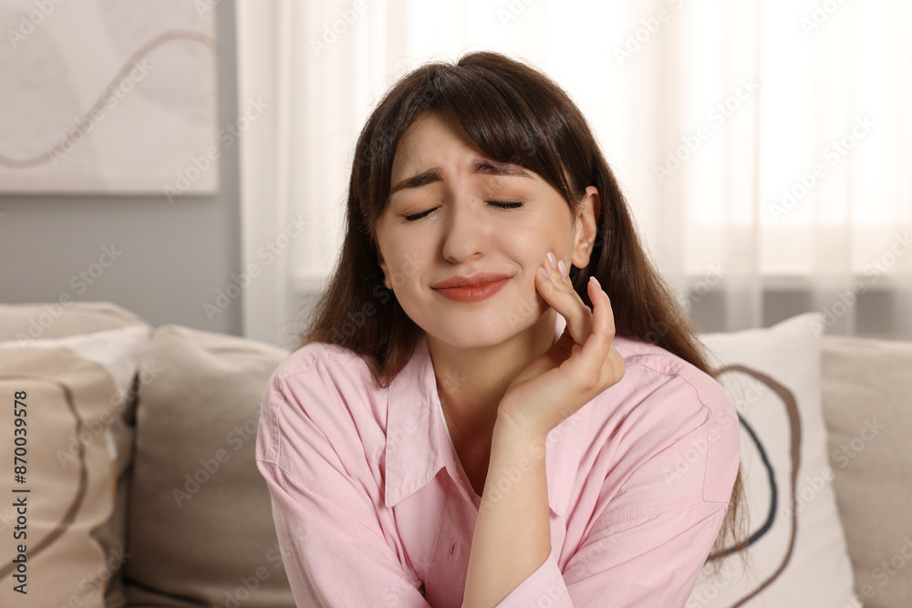 Upset young woman suffering from toothache indoors Upset young woman suffering from toothache indoors