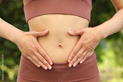 Healthy digestion. Woman touching her belly outdoors, closeup