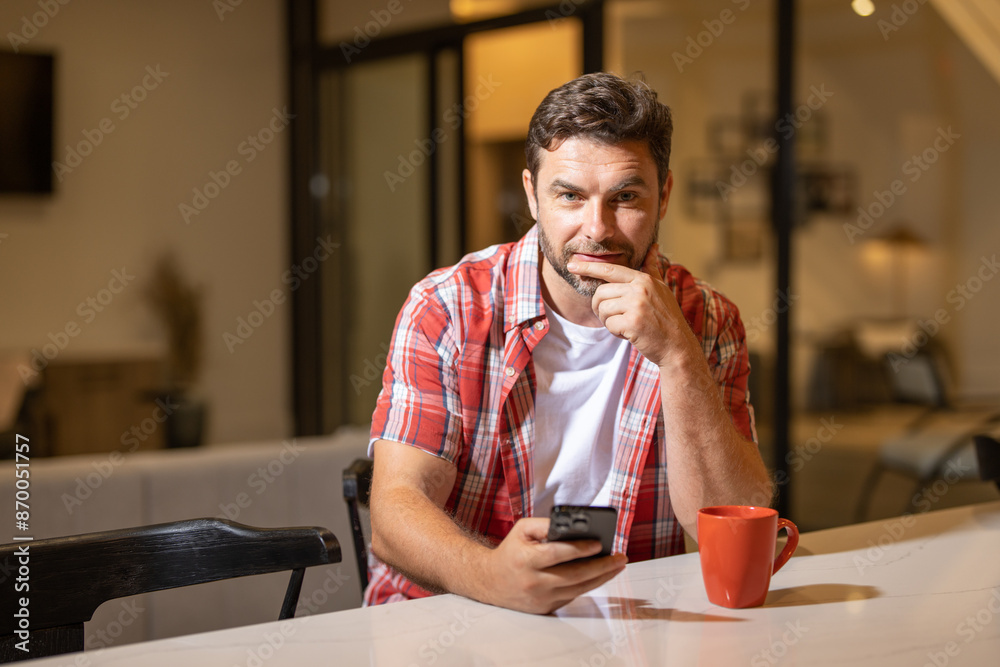 Portrait of a cheerful man with smart phone at night home. Guy using phone at home. Middle eastern mature man using phone for online payment. Man using cellphone. Guy using smart phone and mobile app. Portrait of a cheerful man with smart phone at night home. Guy using phone at home. Middle eastern mature man using phone for online payment. Man using cellphone. Guy using smart phone and mobile app.
