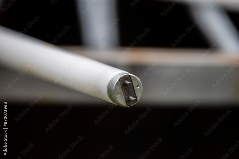 A closeup of a white fluorescent lamp on a black background. A closeup of a white fluorescent lamp on a black background.