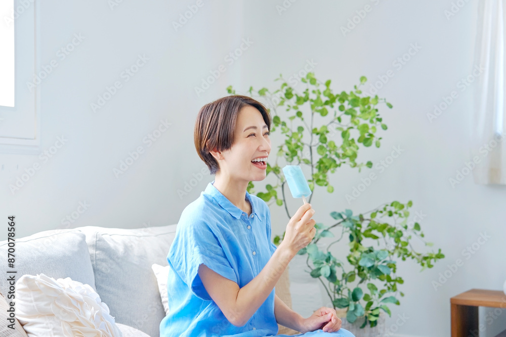 自宅で棒アイスを食べる女性 自宅で棒アイスを食べる女性