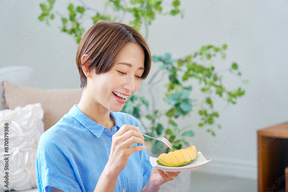 自宅でメロンを食べる女性 自宅でメロンを食べる女性