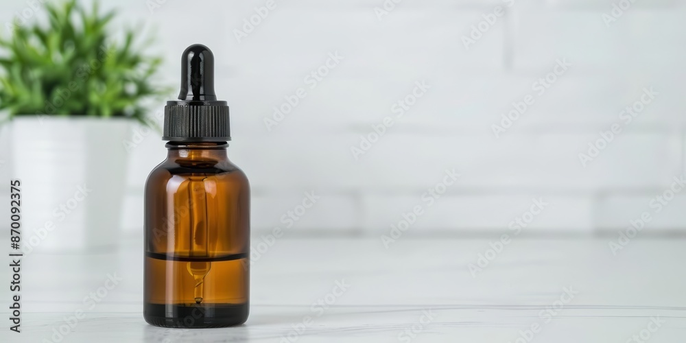 Amber glass dropper bottle on a white marble surface with a green plant in the background, ideal for essential oils and skincare products. Amber glass dropper bottle on a white marble surface with a green plant in the background, ideal for essential oils and skincare products.