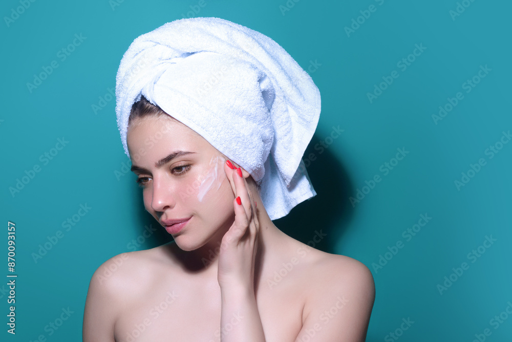 Beautiful model applying cosmetic cream treatment on face. Facial treatment. Beauty portrait of young topless woman with bare shoulders applying face cream. Beautiful model applying cosmetic cream treatment on face. Facial treatment. Beauty portrait of young topless woman with bare shoulders applying face cream.