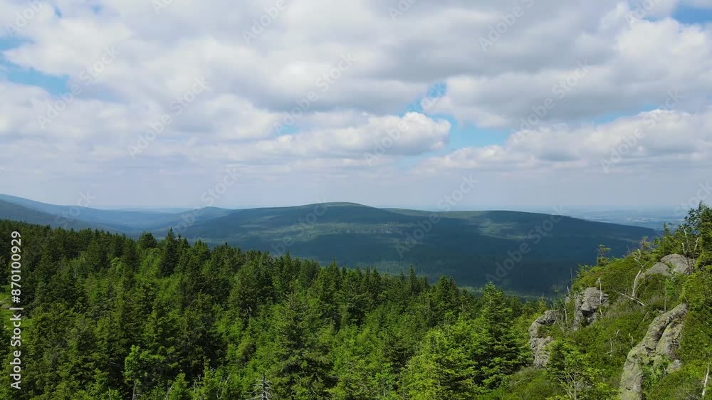 Towering rock formations stand amidst a lush green forest under a clear sky in Saxon Switzerland Mountains range in Germany. Towering rock formations stand amidst a lush green forest under a clear sky in Saxon Switzerland Mountains range in Germany.