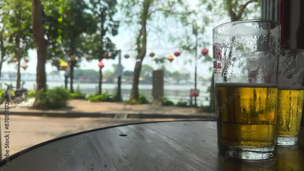 Glasses of cold beer. Glass of beer on a wooden table. Traditional Bia Hoi Vietnamese beer over looking Truc Bach lake. Ha Noi, Vietnam.