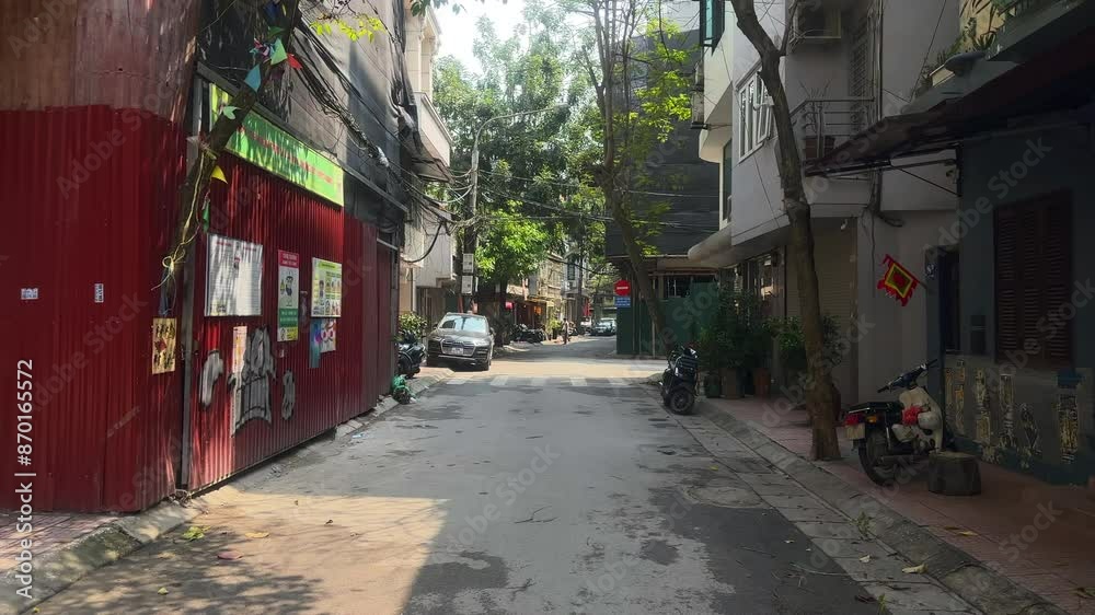 View of an inner city street in Asia. Urban street with apartments, cars and scooters. A street on Truc Bach island. Ha Noi, Vietnam.