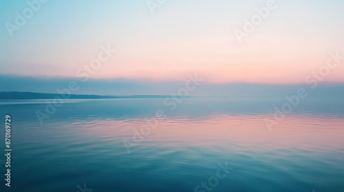 The calm waters of a lake at sunrise, with the sky painted in pastel colors, provide a perfect moment of serenity and reflection.
