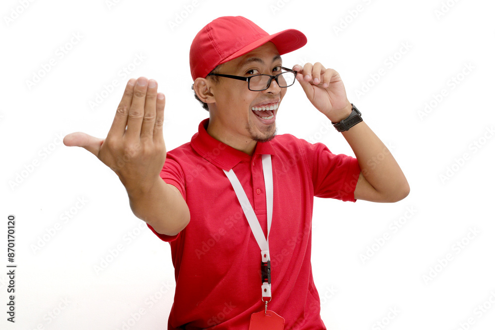 Excited Asian delivery man or courier Beckoning with extends a 'come here' gesture towards the camera, inviting viewers to come closer or join him, isolated on a white background