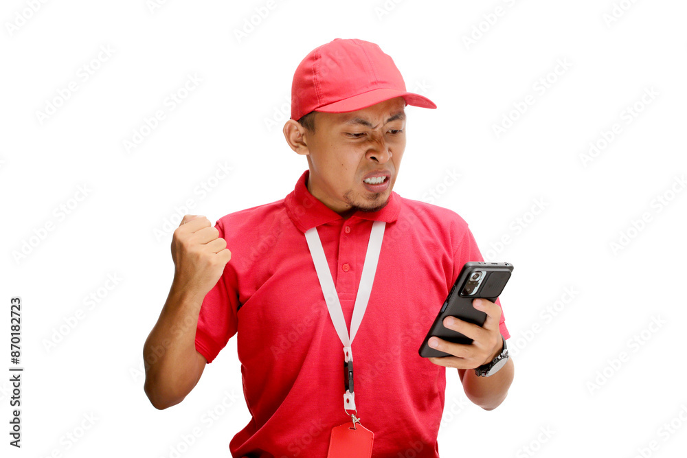 An upset Asian delivery man or courier reacting angrily to bad news, delay, or shipment problems on his smartphone. Isolated on a white background An upset Asian delivery man or courier reacting angrily to bad news, delay, or shipment problems on his smartphone. Isolated on a white background
