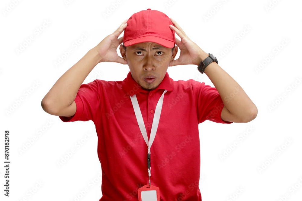 Shocked and anxious Asian delivery man or courier is captured in a moment of panic, grabbing his head with both hands and displaying a worried expression. Isolated on a white background, Shocked and anxious Asian delivery man or courier is captured in a moment of panic, grabbing his head with both hands and displaying a worried expression. Isolated on a white background,
