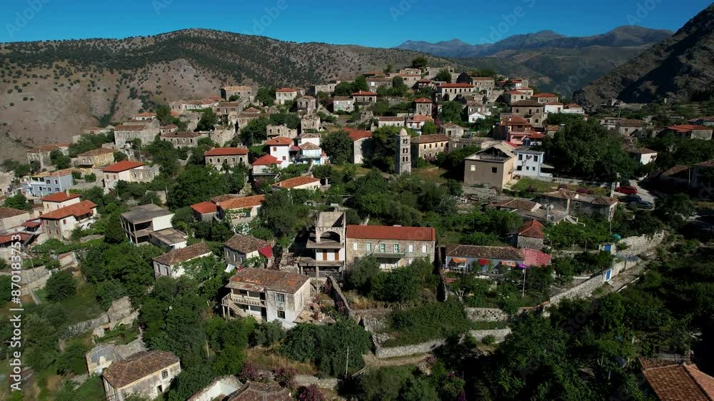 Picturesque Village of Qeparo with Old Stone Houses Around Church with Bell Tower on Albanian Coast, Facing the Sun Picturesque Village of Qeparo with Old Stone Houses Around Church with Bell Tower on Albanian Coast, Facing the Sun