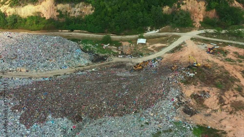 Aerial birds eye view drone flyover and around a landfill site with unsorted wastes, showcasing environmental sustainability, microplastics and causes of global warming and climate change. photo