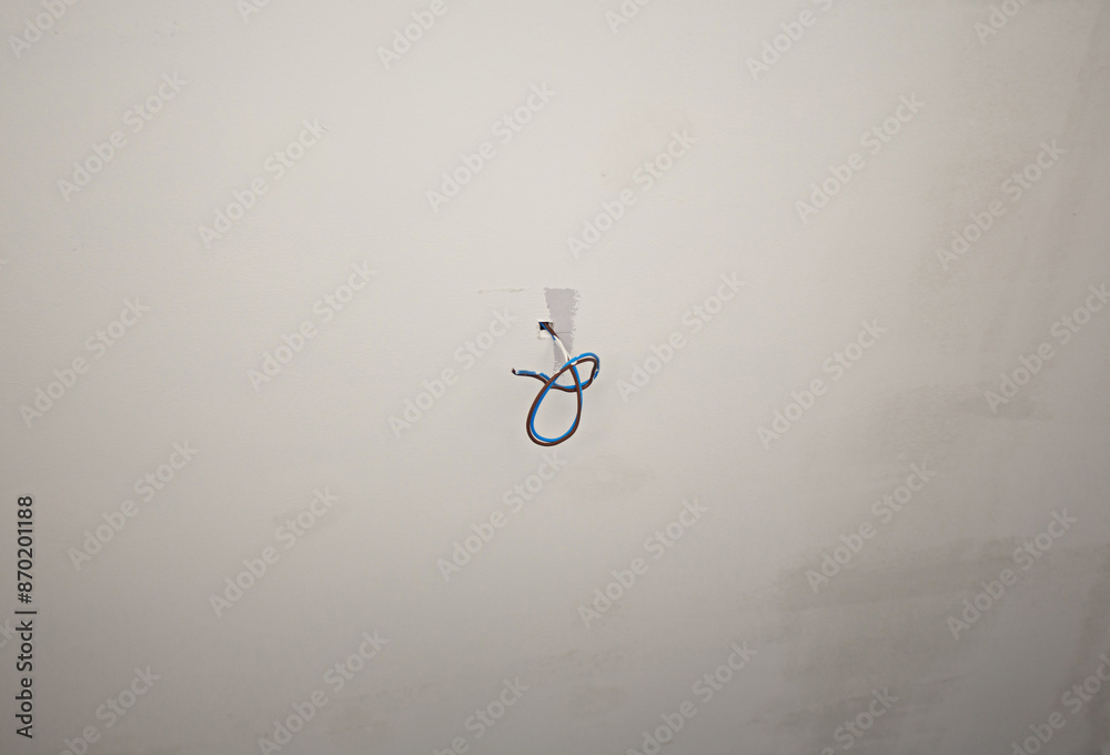 Electric wires emerge from the white ceiling. Electric wires emerge from the white ceiling.
