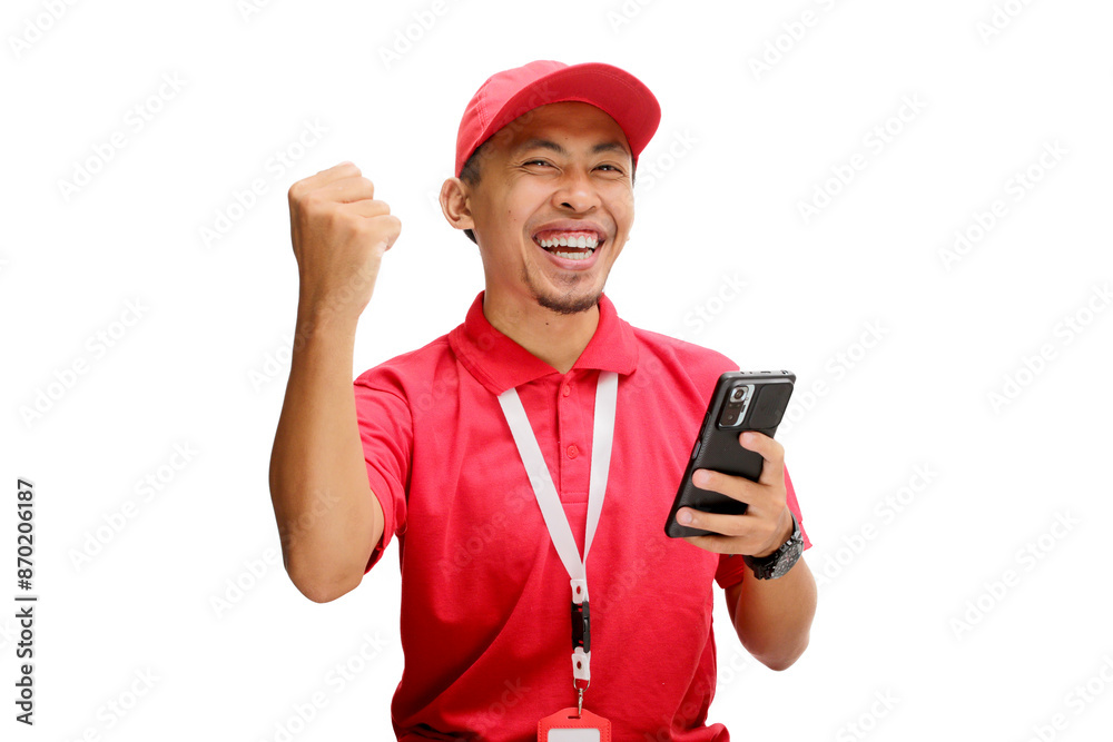 Excited Asian delivery man or courier feeling surprised after winning a prize for free delivery on a limited offer, as seen on his phone. Isolated on a white background
