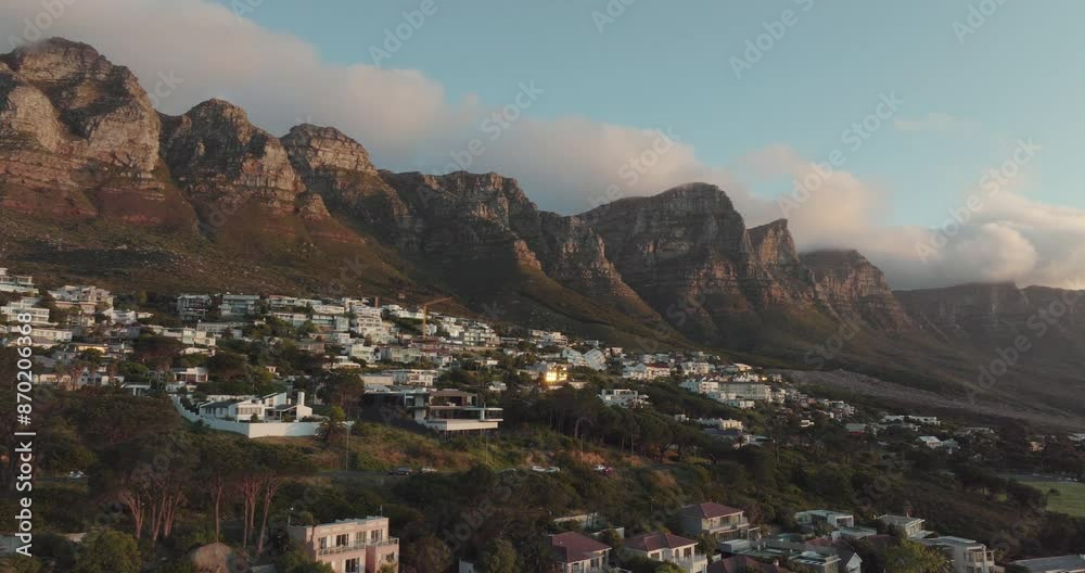 Drone flying slowly sideways over Camps Bay in Cape Town South Africa - View of Table Mountain at sunset with light clouds Drone flying slowly sideways over Camps Bay in Cape Town South Africa - View of Table Mountain at sunset with light clouds