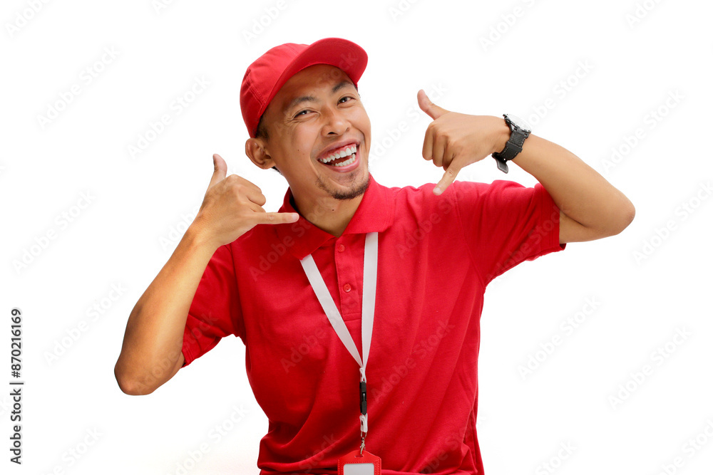 Asian delivery man or courier stands confidently against a white background, making a playful 'call me' gesture with his hand. Concepts of customer engagement, communication, and delivery services Asian delivery man or courier stands confidently against a white background, making a playful 'call me' gesture with his hand. Concepts of customer engagement, communication, and delivery services