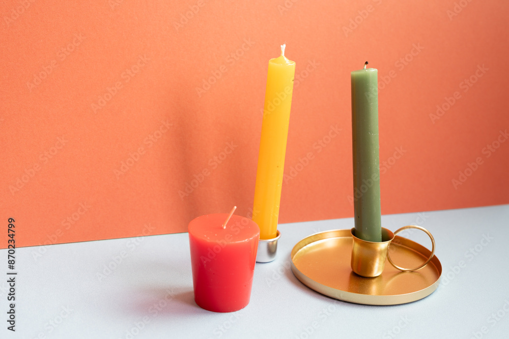 Candle on gray table. red wall background