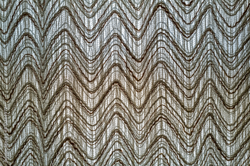 Fototapeta premium A contemporary cloth curtain hanging backlit in the window