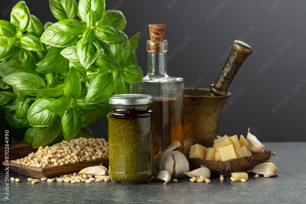 Pesto sauce and ingredients on a black stone table. Pesto sauce and ingredients on a black stone table.