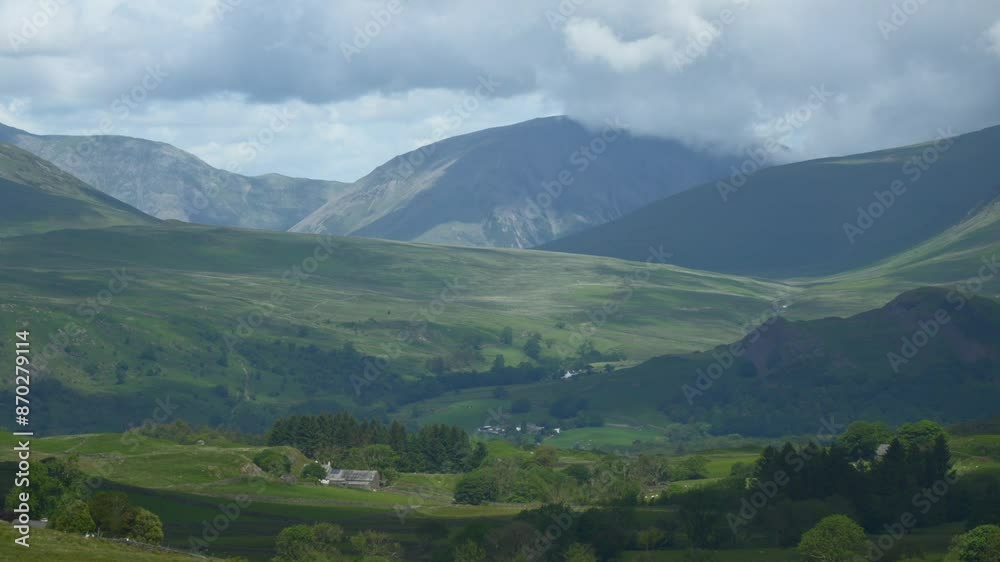 Thick cloud skimming mountain tops as shadows race across verdant countryside with isolated dwellings nestled in hills. Timelapse 30x. English Lake District, Wasdale, Cumbria, UK Thick cloud skimming mountain tops as shadows race across verdant countryside with isolated dwellings nestled in hills. Timelapse 30x. English Lake District, Wasdale, Cumbria, UK