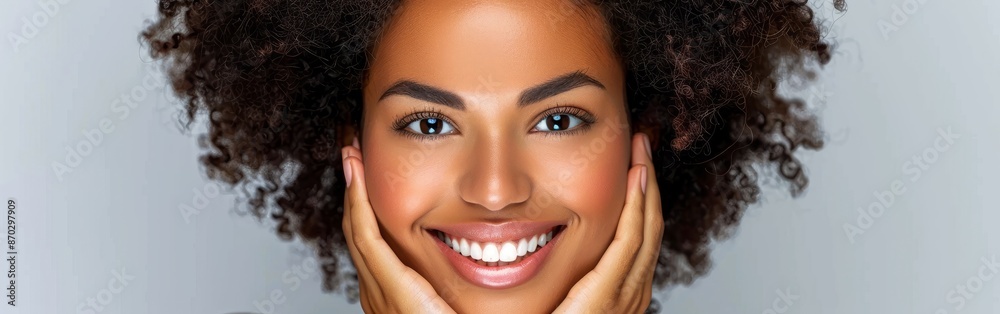 Closeup portrait of an African American woman smiling with her hands resting on her face Closeup portrait of an African American woman smiling with her hands resting on her face