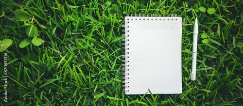Notebook placed on lush gre...