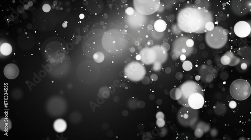 A black and white image of abstract white bokeh lights against a dark background