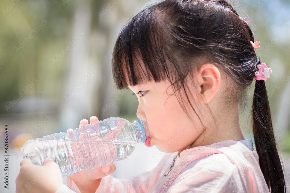 Close Up little girl drinking water from bottle in the park. Portrait outdoor.
Close Up little girl drinking water from bottle in the park. Portrait outdoor.