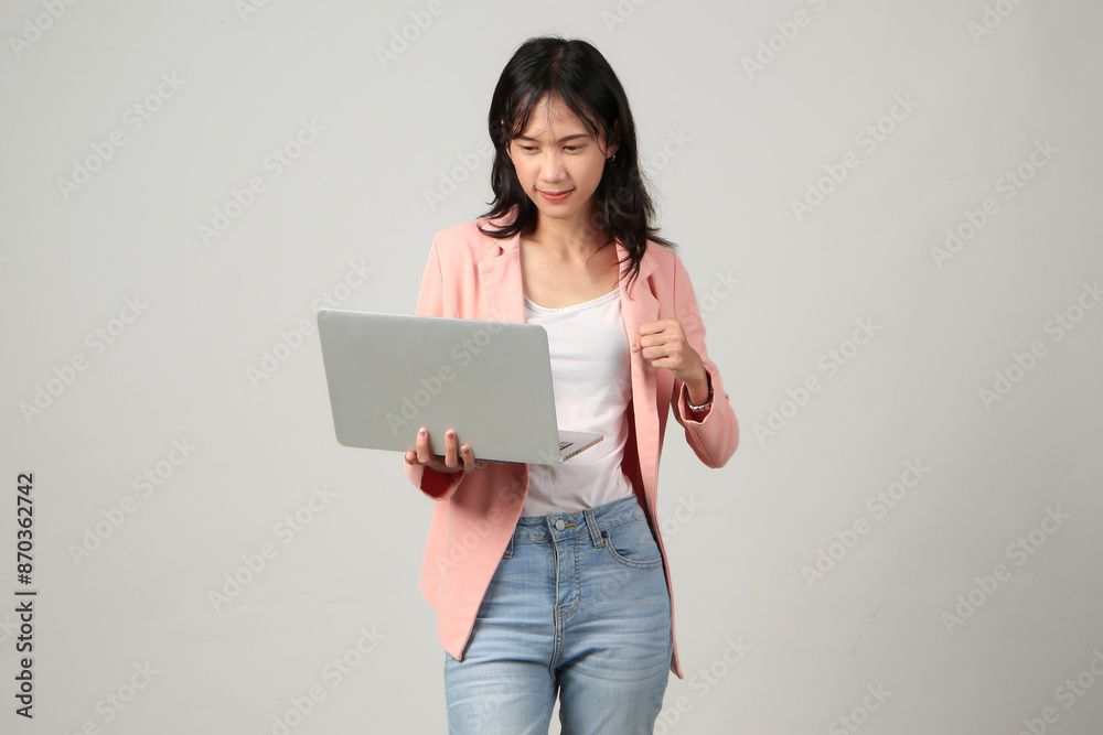 angry upset mad asian woman wearing formal casual outfit holding laptop computer on isolated background. angry upset mad asian woman wearing formal casual outfit holding laptop computer on isolated background.