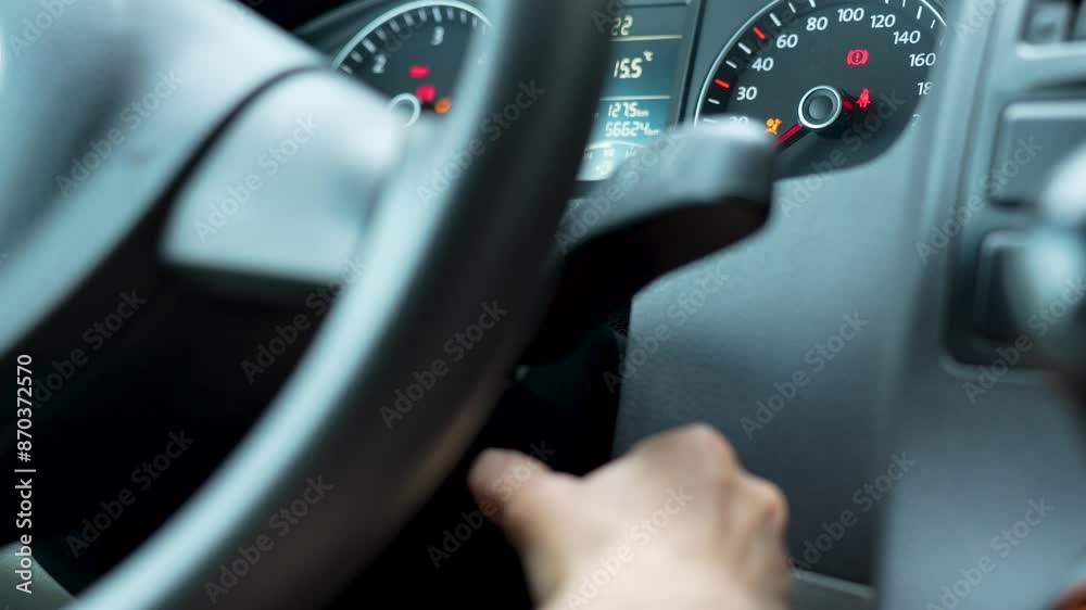 Close-up of a woman hand inserting the car keys into the car socket and starts the engine Close-up of a woman hand inserting the car keys into the car socket and starts the engine
