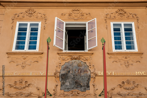 The facade with a religious fresco and white windows