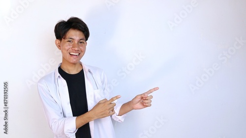 Excited young Asian man gesturing pointing to the side