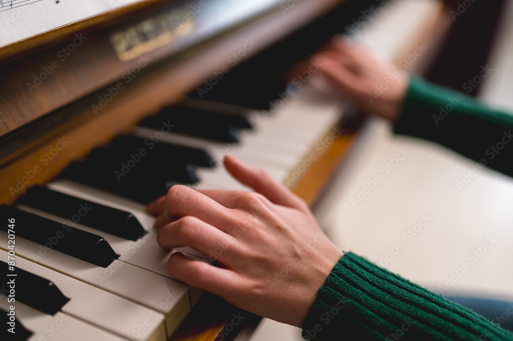 Fototapeta premium Close up shot of girl hands playing piano