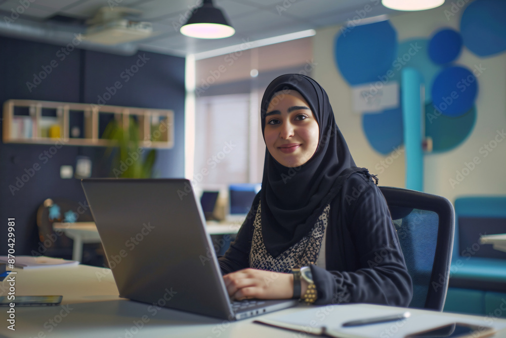 Muslim Woman Working on Laptop in Modern Office.