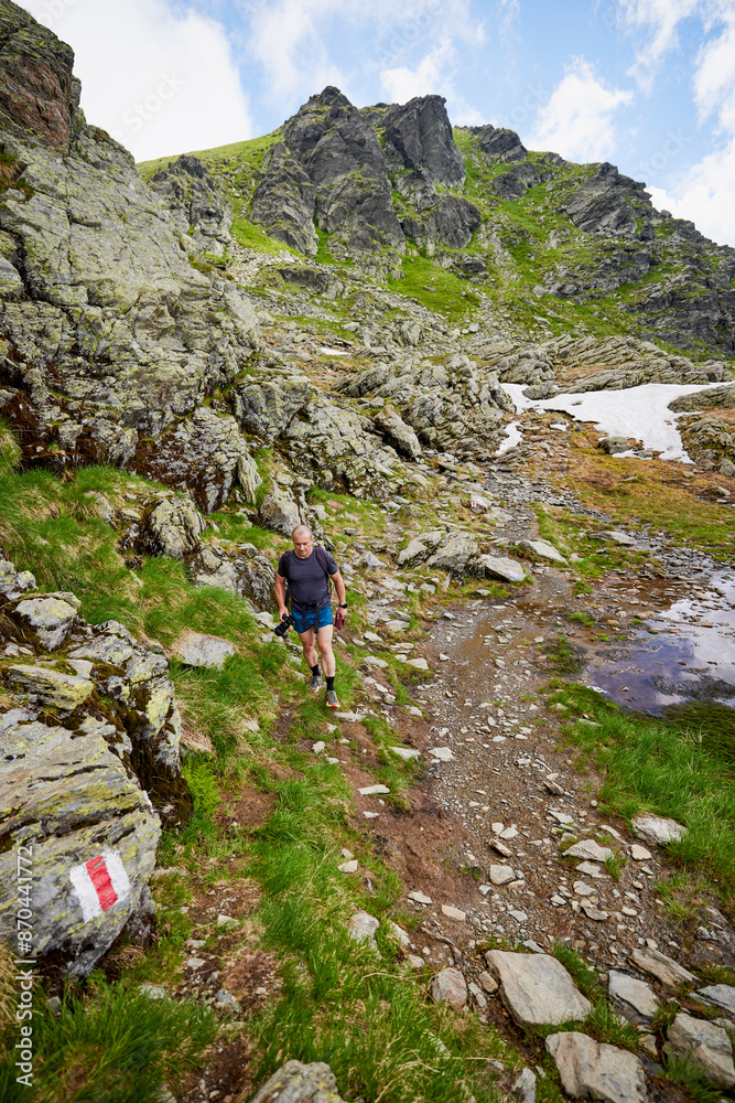 Fototapeta premium A middle-aged man walking on the mountain