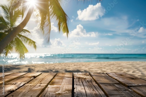 An image of a wooden floor or plank on a sand beach in the summer. For product display purposes. Calm sea and blue skies in the background.