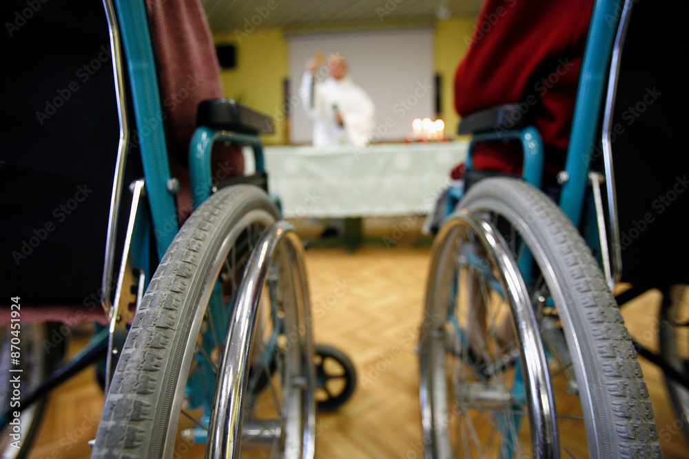 Obraz premium Retirement home. Old person on wheel chair. Christmas mass.. France.