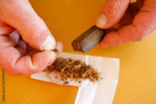 Man preparing a hashish joint. Drugs among young people.