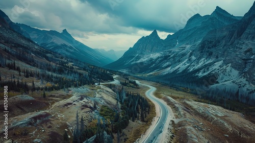 Beautiful aerial view of mountains with winding road surrounded by trees and clear cloudy sky