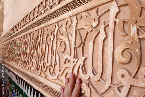 Ben Youssef Medersa is the largest Medersa in Morocco, Originally a religious school founded under Abou el Hassan. Calligraphy in the patio.  The word Allah. Morocco. photo