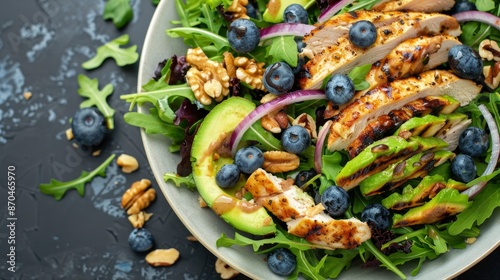 A Delicious Salad Featuring Blueberries, Grilled Chicken, Creamy Avocado, Red Onions, Walnuts, And Peppery Arugula