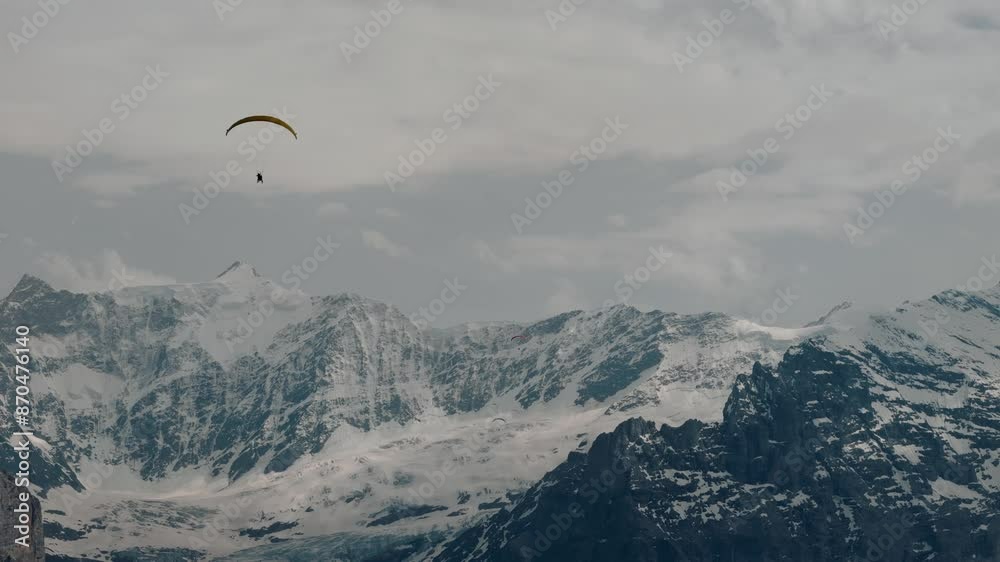 Paraglider Moving Towards Snowy Alps in Switzerland Paraglider Moving Towards Snowy Alps in Switzerland