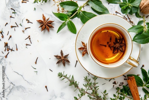 Aromatic herbal tea in elegant cup on marble background with spices
