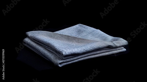 Men's light grey shalwar qamiz neatly folded on a black background.