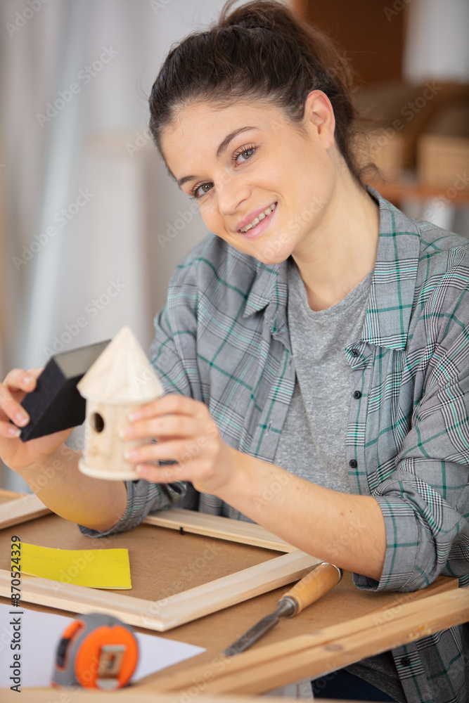 young woman building bird house young woman building bird house
