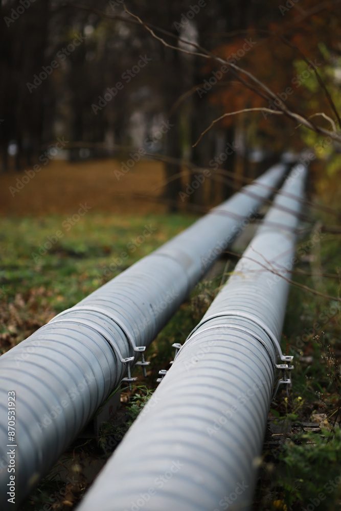 Fototapeta premium Metal pipes on the street. pipes from the pipeline. gas pipeline for gas pumping. heat-pipe. large silver colored pipe for hot water.